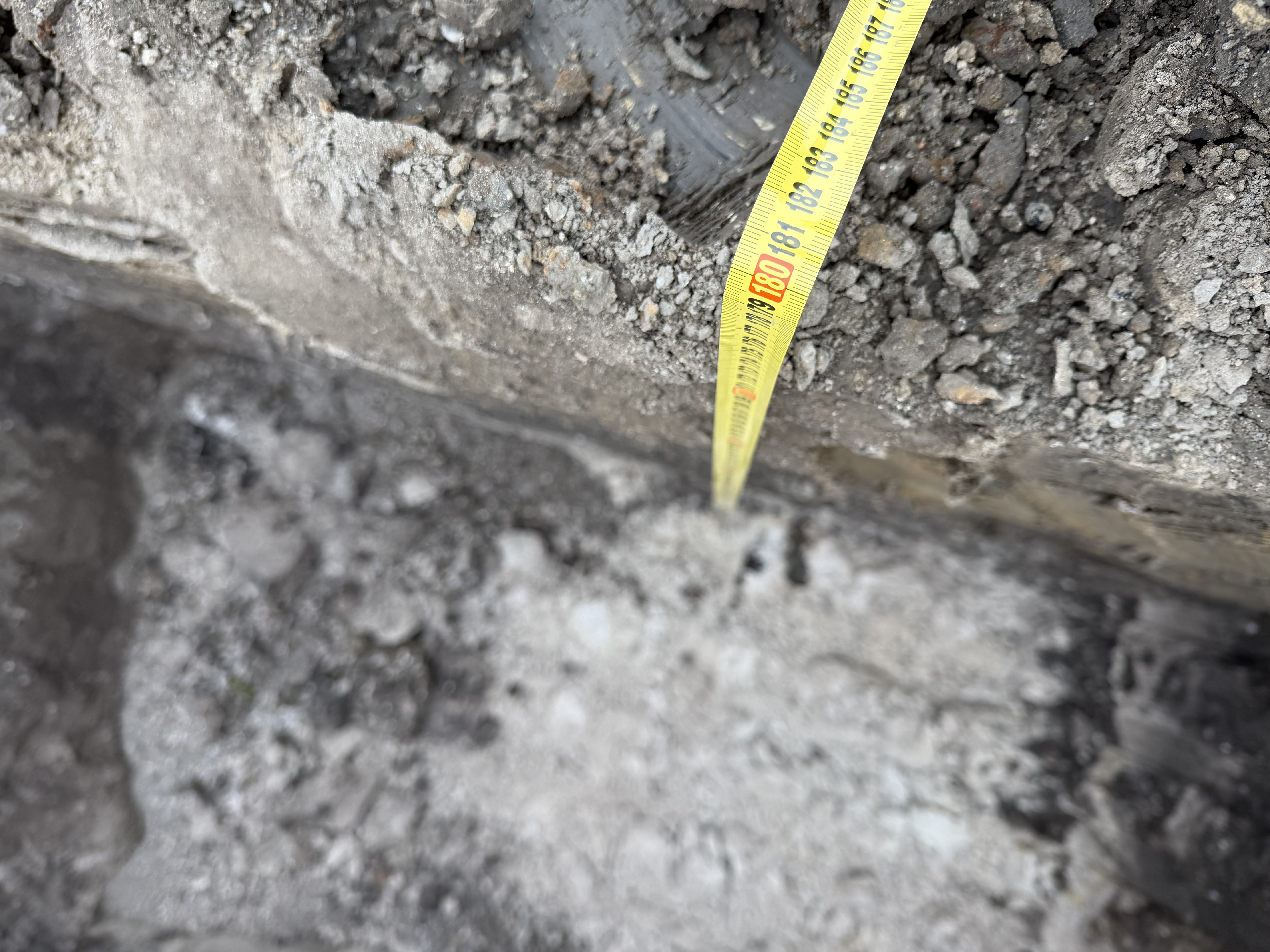 Detailní záběr vrstev zeminy s měřicím pásmem při geologickém průzkumu