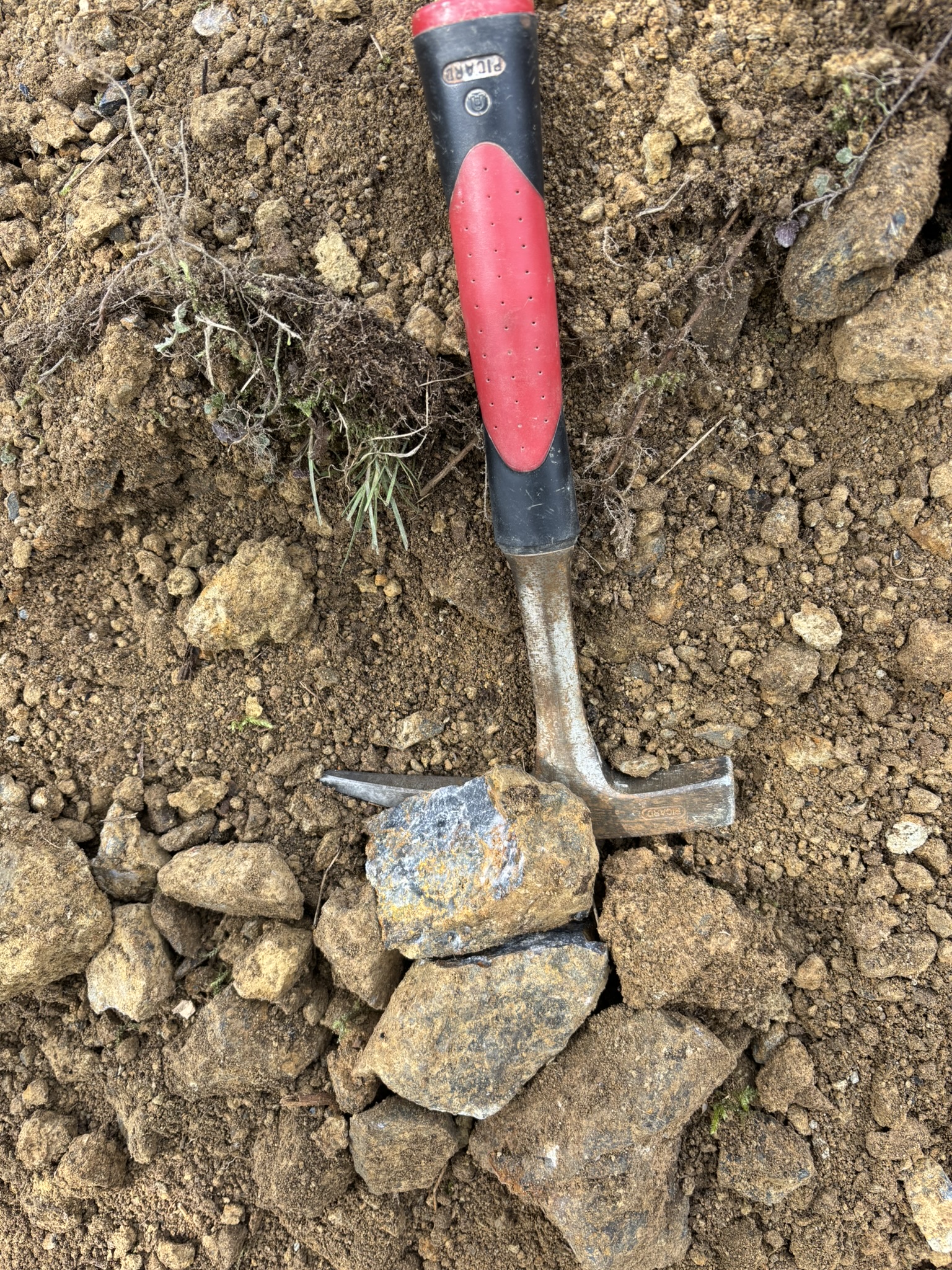 Geologické kladivo na vzorku horniny